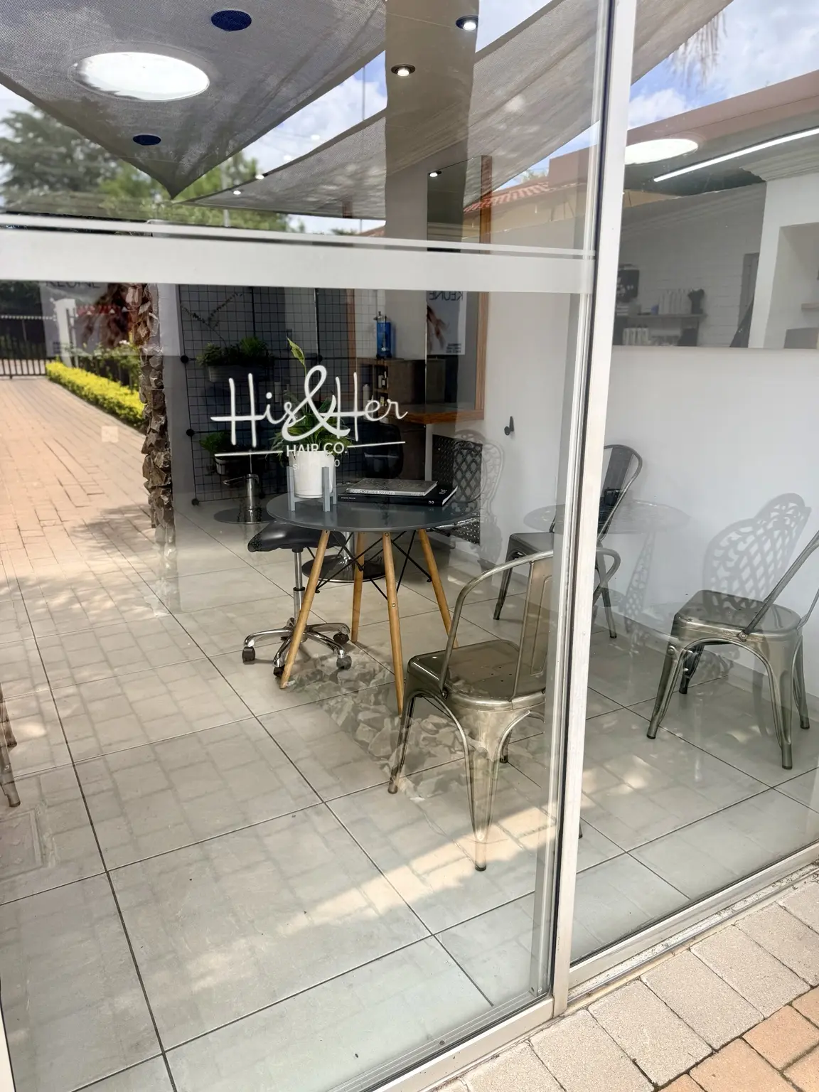 The glass entrance to His & Her Hair Co